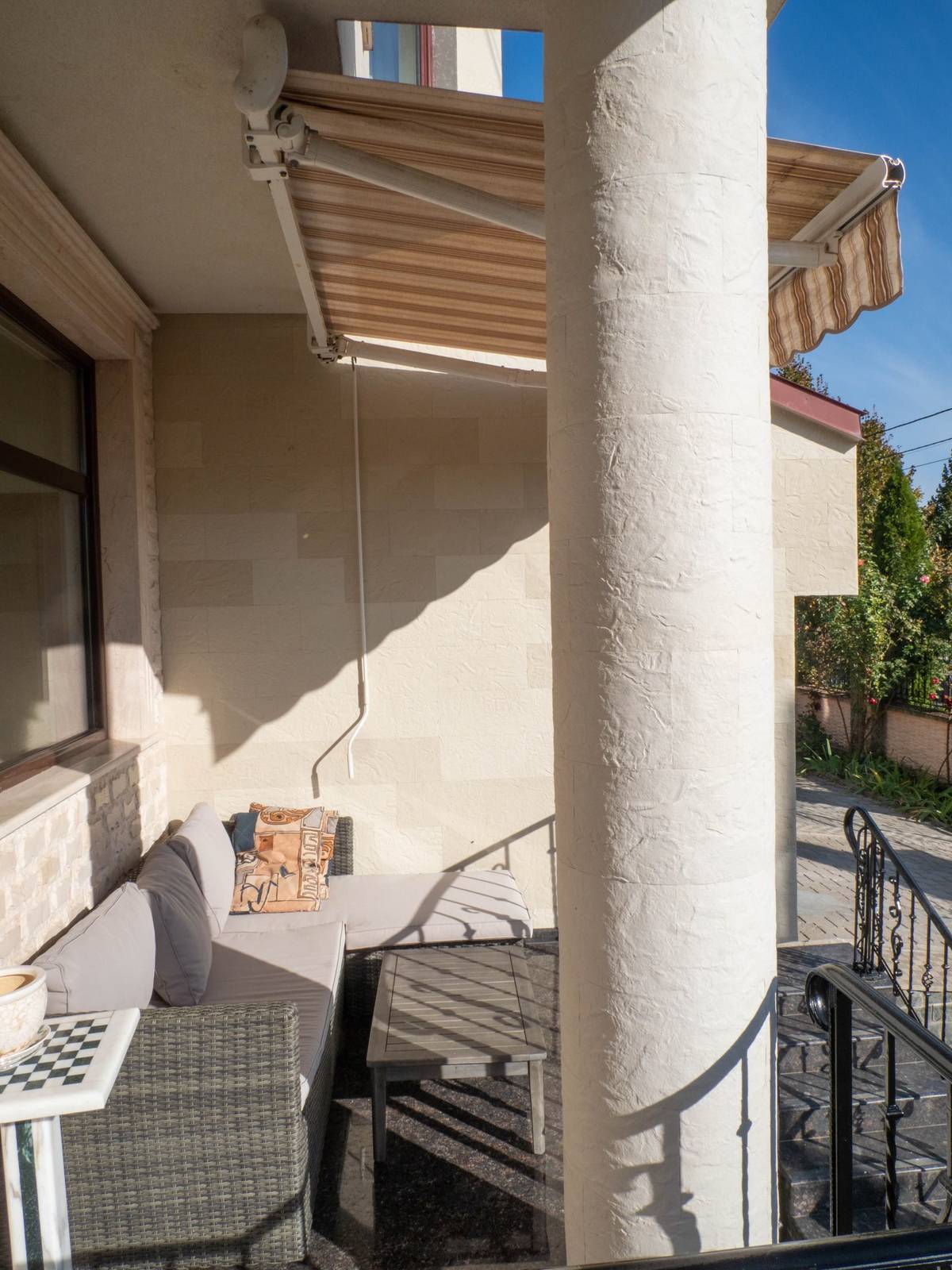 Colonne ronde de la terrasse, enveloppée de pierre flexible avec joints suivant le rayon
